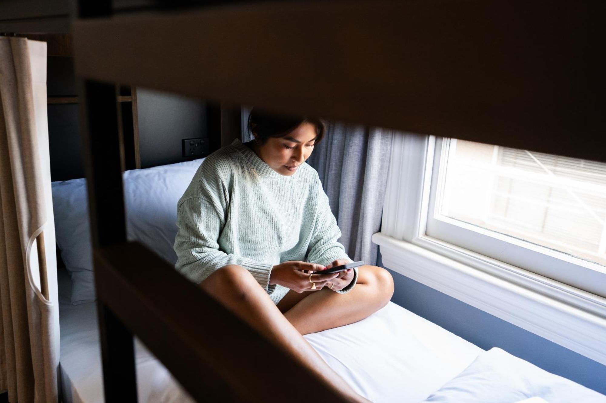 Ostello Haka House Distretto di Rotorua Esterno foto A woman sitting on a bunk bed